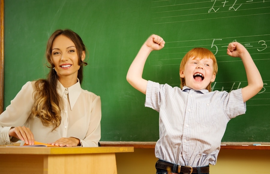 little happy redhead boy answering near blackboard in school - 塾選びの大切なポイント！その先生はお子様の恩師になれますか？